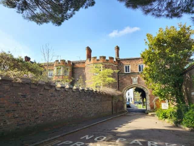Brick gatehouse with battlements and a stone archway