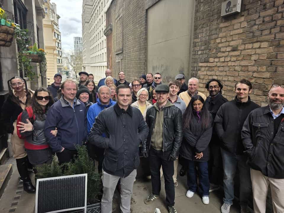 Tour group outside a historic building with stone columns