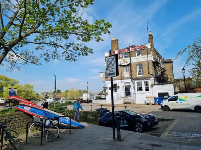 The White Cross pub beside the river, with trees overhead